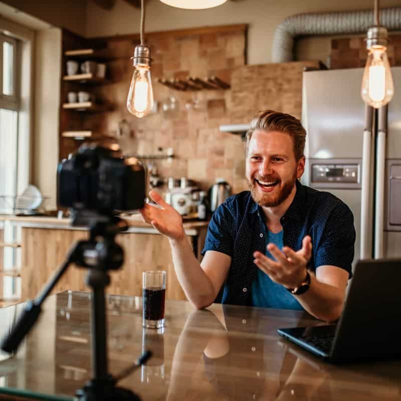 a man casually vlogging with a kitchen in the background