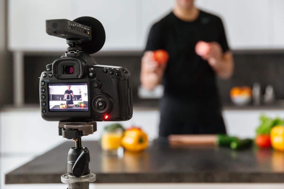 Camera with a man recording a cooking video